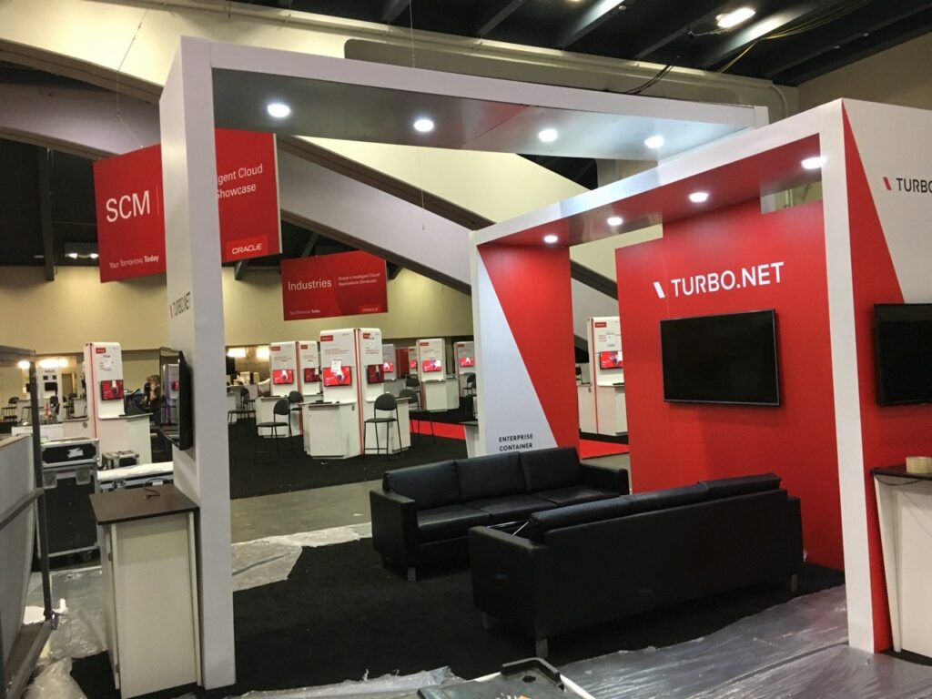 Custom Trade show rental design features arch towers with downlighting and modern work stations