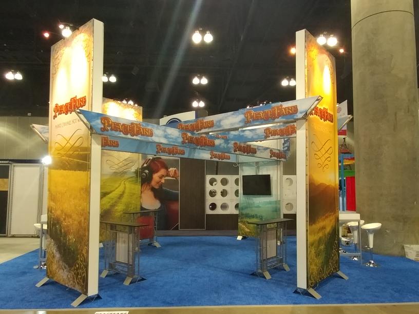 Rental trade show exhibit design features 14 ft. tall graphic walls 23 foot chisel header beam graphics and presentation area